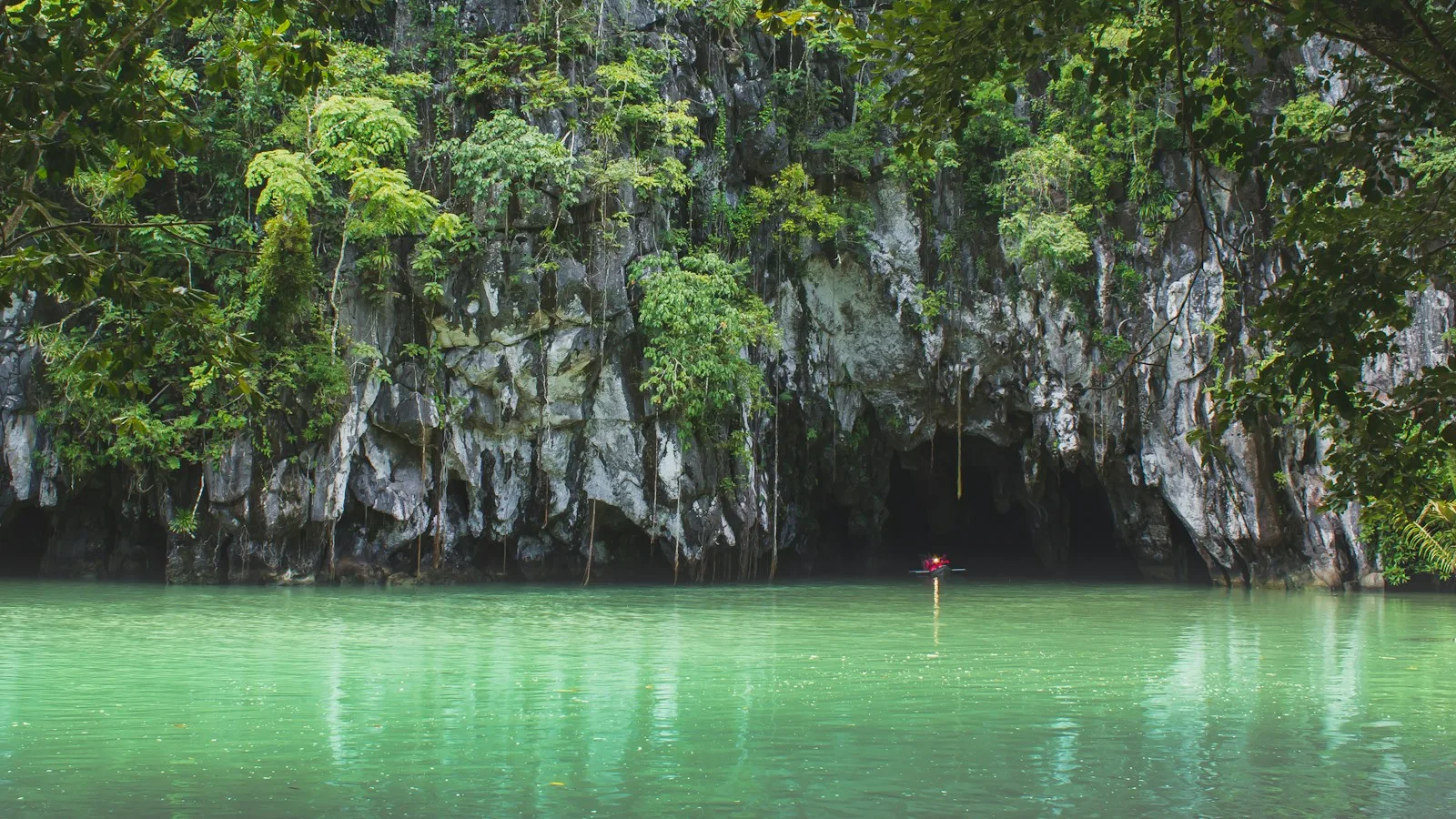Bangka à l'entrée de la rivière souterraine de Puerto Princesa, falaises calcaires et jungle à Sabang, Palawan